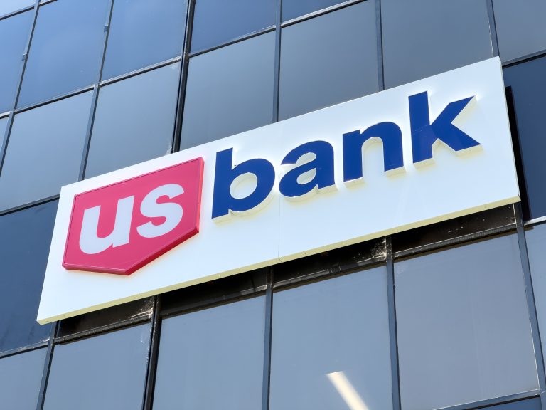 The logo of U.S. Bank on an office building, representing the pivotal role American banks are playing in financing the green energy transition.
