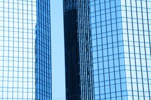 Two tall glass skyscrapers side by side in Zurich symbolizing the merger of Swiss insurers Baloise and Helvetia into a new financial powerhouse.