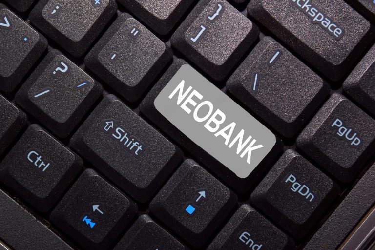 A close-up of a black computer keyboard with a special gray key that has the word "NEOBANK" written on it. The image symbolizes the digital-first nature of neobanks, which is the central topic of the article.