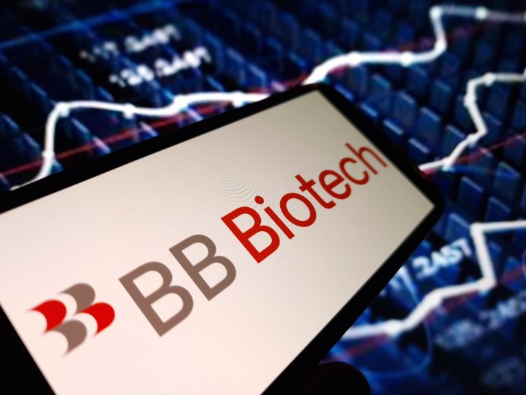 The BB Biotech logo is displayed on a smartphone, set against a blurred background of a financial stock chart.
