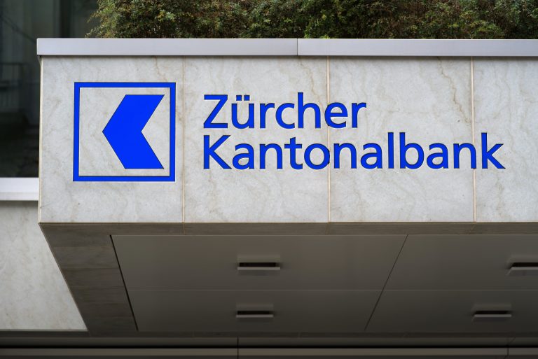 The Zürcher Kantonalbank (Zurich Cantonal Bank) logo is shown on a sign attached to a building.